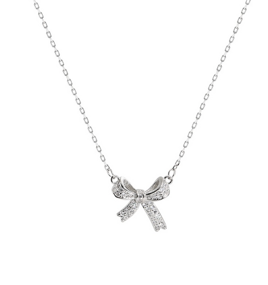 “Close-up of a 925 silver bowknot necklace with sparkling zircon stones on a rhodium-plated chain casting a soft shadow.”