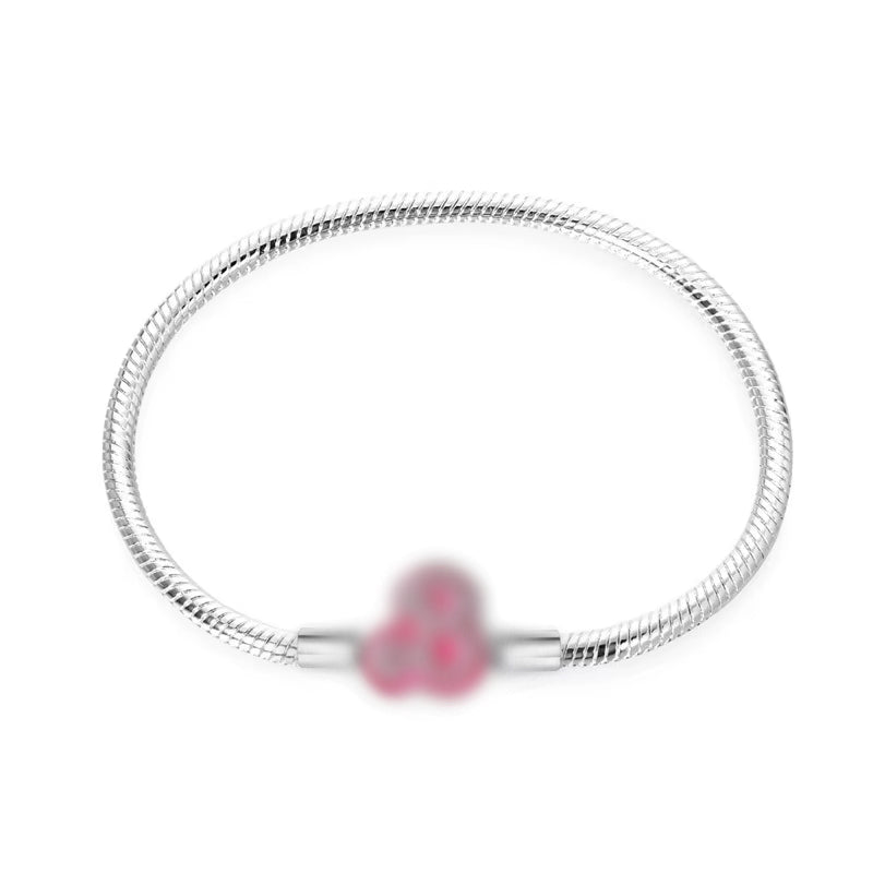 Silver bracelet with a pink heart charm on a white background