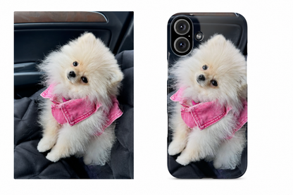 Phone case with a cute white dog wearing a pink outfit on a car seat.