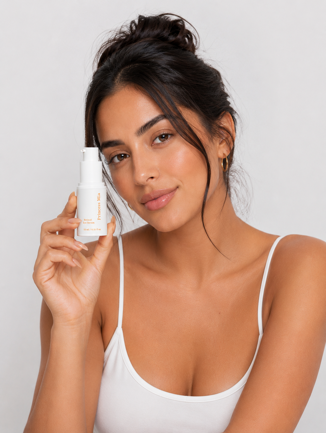Woman holding Princess Mia Retinol Eye Serum designed to visibly reduce dark circles, smooth fine lines, and brighten the under-eye area.